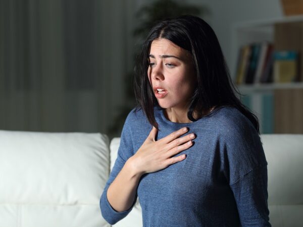 Woman Suffering An Anxiety Attack Alone In The Night On A Couch At Home